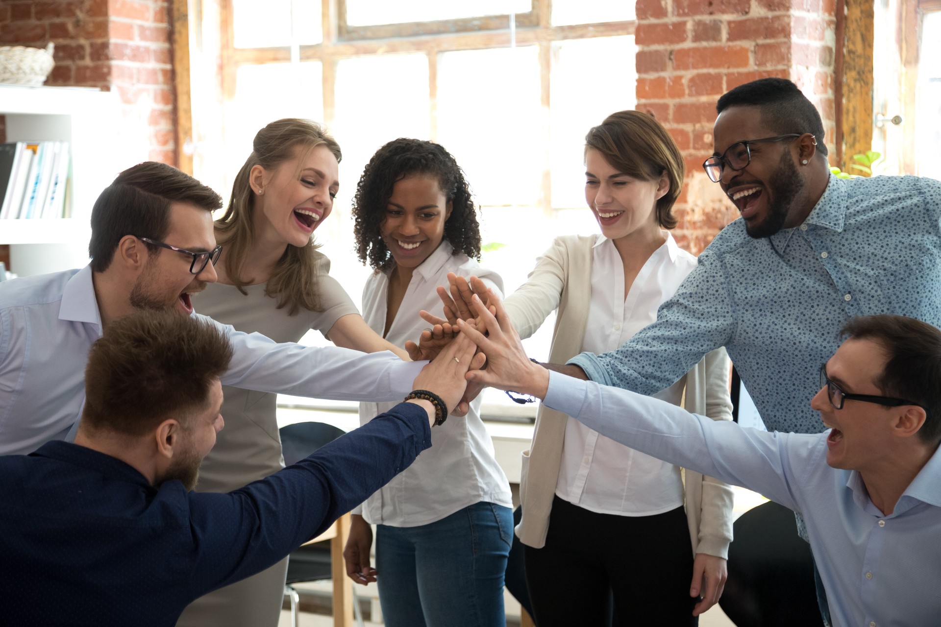 Happy diverse colleagues give high five together celebrate great teamwork